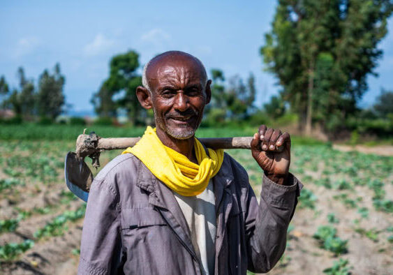 Zwarte man met schop op veld in Afrika, sociaal project, landbouw, ontwikkeling, dorcas.