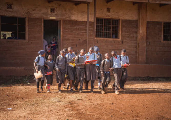 Gezonde schoolkinderen in uniform lopen netjes in rij voor onderwijs in een Kenyaanse school.