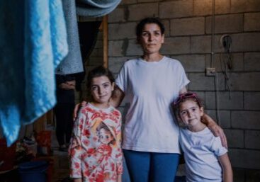 Gevouwen handdoeken en kleding hangen te drogen in een communitycentrum.